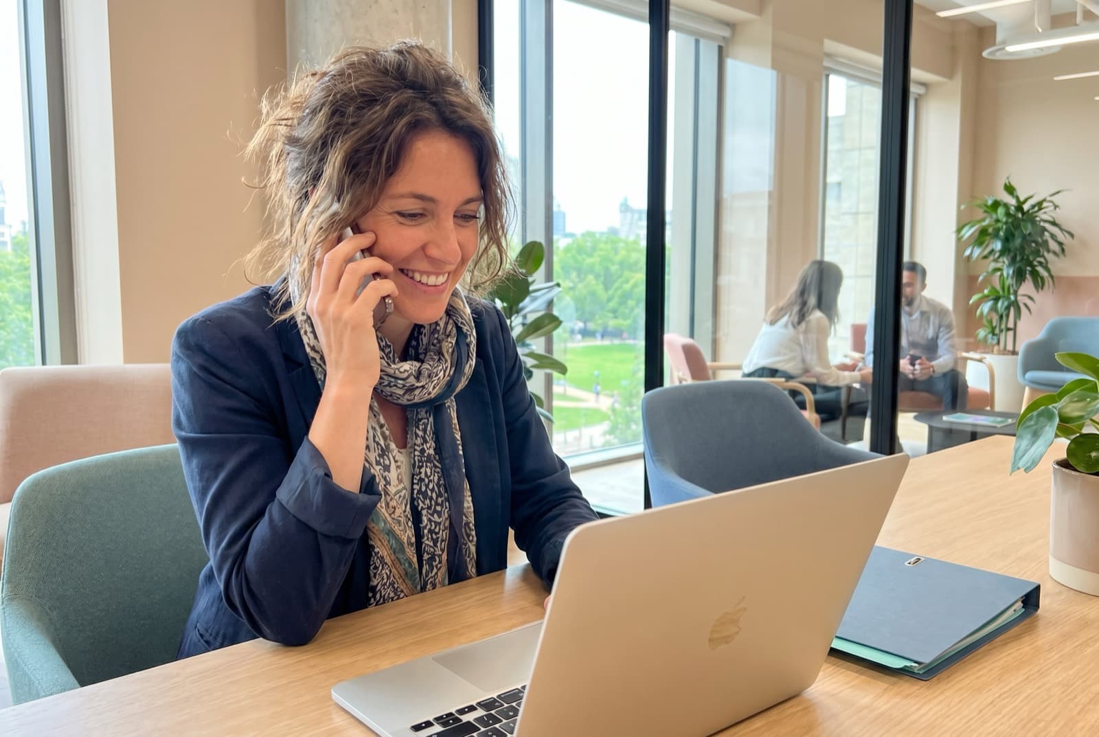 Une conseillère de L'Atelier des Experts au téléphone dans un bureau lumineux
